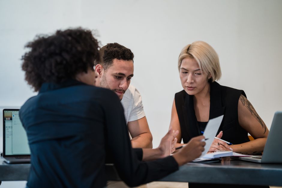 Three colleagues reviewing a document during a business meeting
