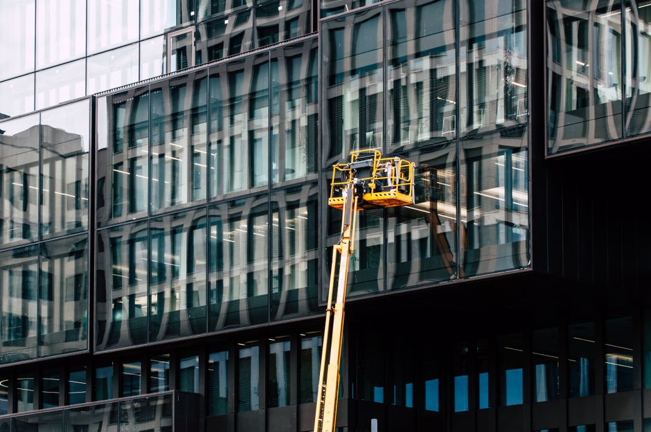 A lift performing maintenance on a commercial building facade
